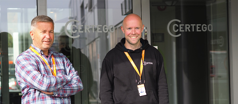 Groupleader-and-technichian-smiling-in-front-of-certego-door-999x435