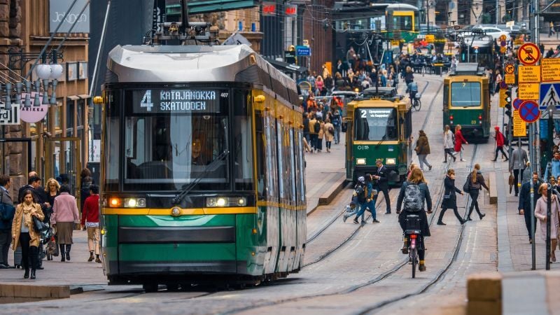 Kävelykatu Helsingissä, ratikka, ihmisiä kävelemässä - Vastuullisuutta työ- ja liikennematkoissa.